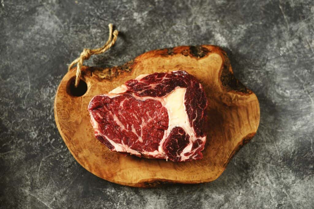 Ribeye maturé, grillé, accompagné de beurre aux herbes et à la truffe 1 planche à découper en bois de bœuf aurocha de qualité supérieure avec côte de bœuf